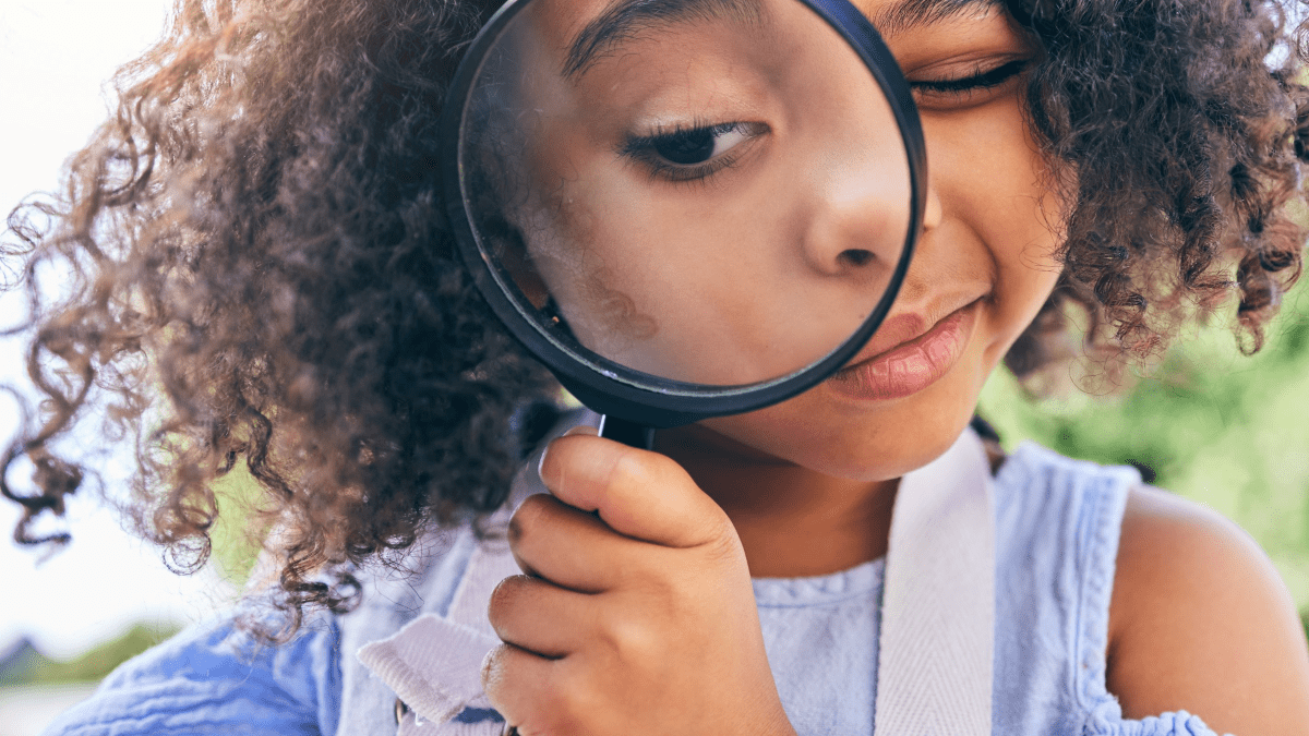 child holding magnifying glass