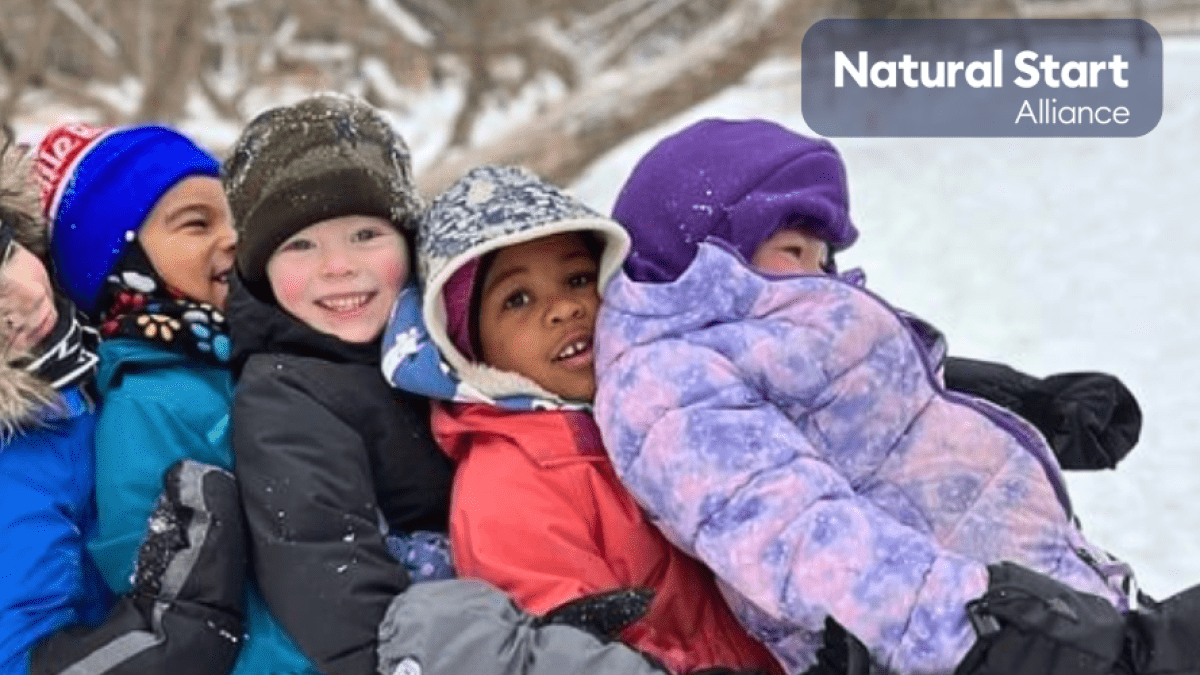 children sitting in a line in the snow