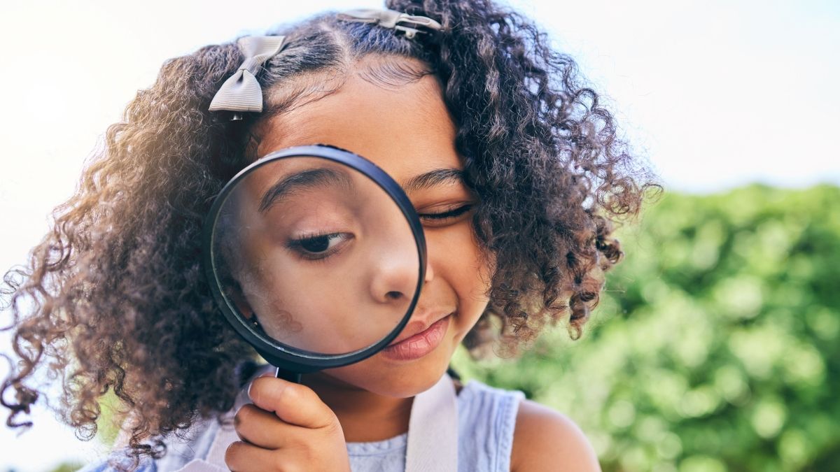 child holding magnifying glass